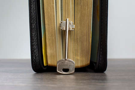 the key lies on the bible book. metaphor for discovering wisdom through the study of religious...