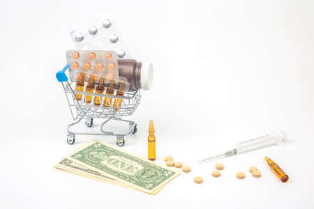 pills, ampoules and syringe for injection and money dollars on a white background. business and...