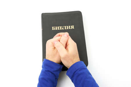Russian book of the Bible in the hands on white background
