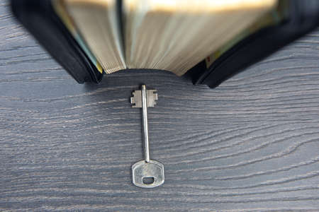 the key lies near the book. metaphor for discovering wisdom through the study of religious...