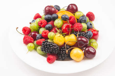 Assorted fresh different berries on a white plate. useful vitamin healthy food fruit. healthy vegetable breakfastの写真素材