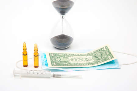 ampoules and syringe for injection, medical mask, money and hourglass on a white background. business and medicine.の写真素材