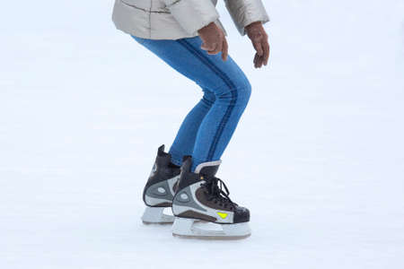 Legs of a man skating on an ice rink. Hobbies and sports. Vacations and winter activities.