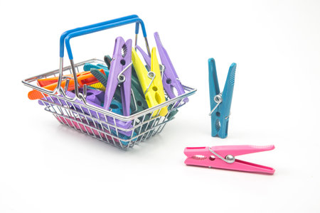 plastic clothespins in a basket on a white backgroundの写真素材
