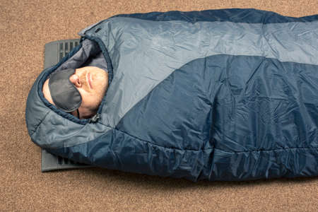 man sleeps in a sleeping bag. items for tourism and camping