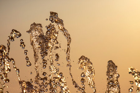 drops of the fountain in the setting sunの写真素材