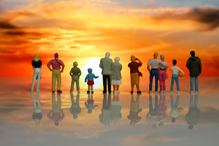Miniature figures. A group of people of different ages watch a beautiful sunset in nature