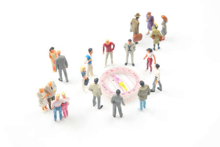 miniature people. different people are standing near the compass. finding direction in lifeの写真素材