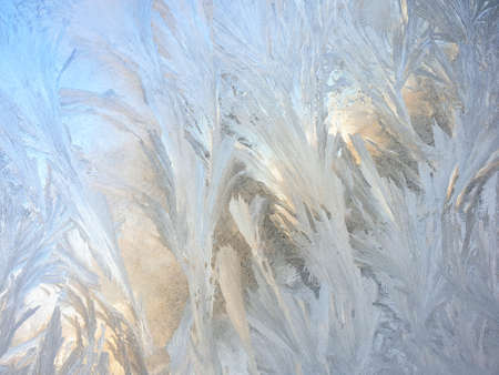 frosty patterns on the window glass closeup. natural textures and backgrounds. ice patterns on...