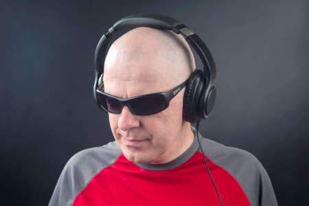 portrait of a man with headphones on his head in relaxation listening to musicの写真素材