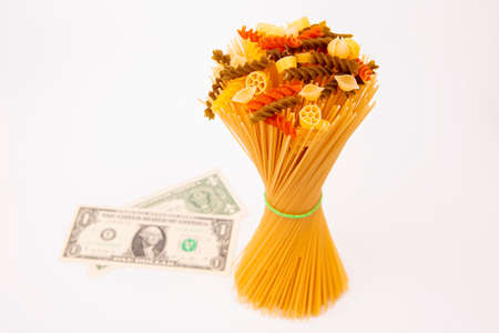 italian pasta with a dollar bill on a white background. flour products and food in cooking