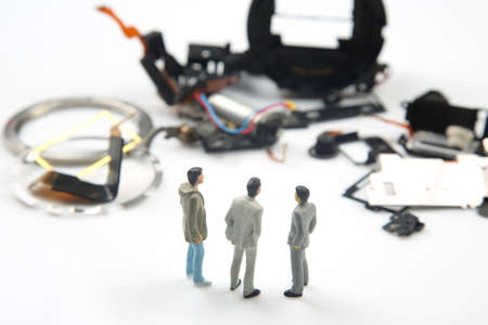 Miniature people. Business men stand near disassembled parts of an electronic device. Business entrepreneur conceptの写真素材