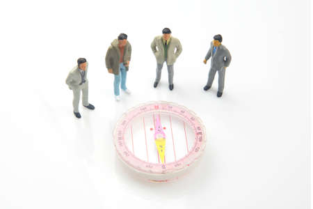miniature people. different people are standing near the compass. finding direction in lifeの写真素材