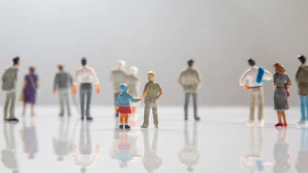 miniature people. different people stand on a white background. communication of society of different generationsの写真素材