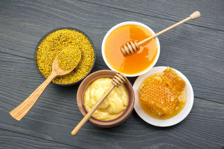 Fresh flower honey of different varieties, pollen and honeycomb with spoons on a wooden background. Organic Vitamin Health Foodの写真素材