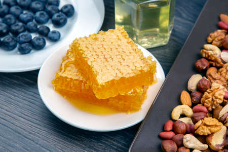 fresh assorted honey, nuts and blueberries on a wooden background. healthy organic vitamin food.の写真素材