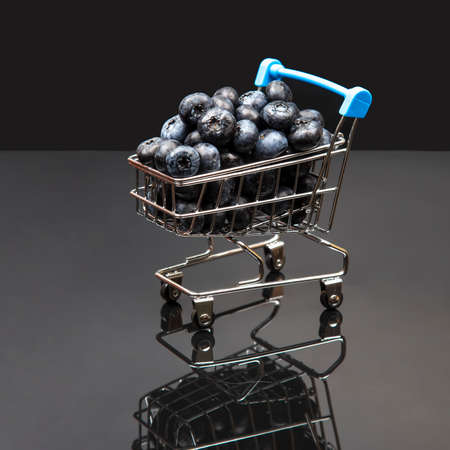 Fresh blueberries in a grocery basket on a background with a mirror image. vitamin food for healthの写真素材