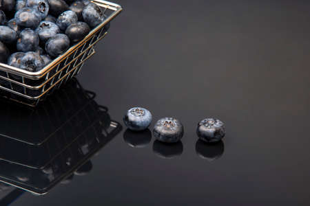 Fresh blueberries in a grocery basket on a background with a mirror image. vitamin food for healthの写真素材