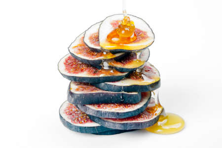figs cut into pieces and drizzled with honey on a white plate. vitamin organic healthy foodの写真素材