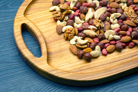 assorted nuts on a kitchen wooden board. vitamin vegetarian food