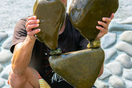 human hands build a cairn of stones on the water. balance and meditationの写真素材