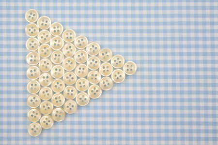 Plastic shiny buttons for clothes on a fabric background. Fashion and clothing. Factory industry.