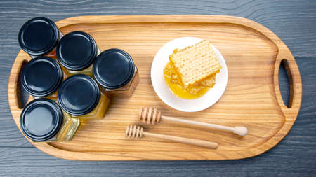 Hexagonal jars with different types and colors of fresh flower honey and a honey spoon. vitamin food for health and lifeの写真素材