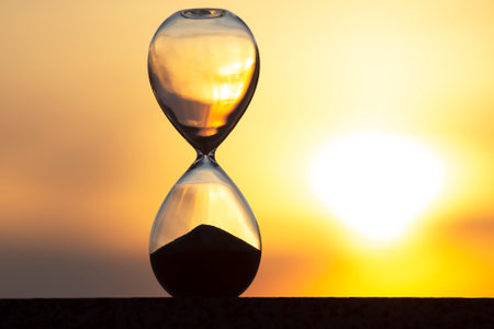 Hourglass on the background of a sunset. The value of time in life. An eternity.の写真素材