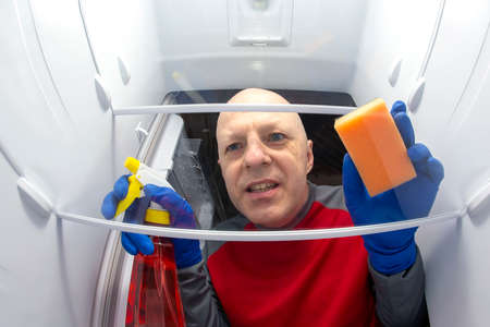 cleaning and washing the inside of the refrigerator with a detergent spray and sponge. professional service for disinfection of kitchen equipment for food preservationの写真素材