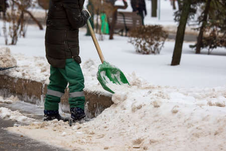street worker shovels snow from the sidewalkの写真素材