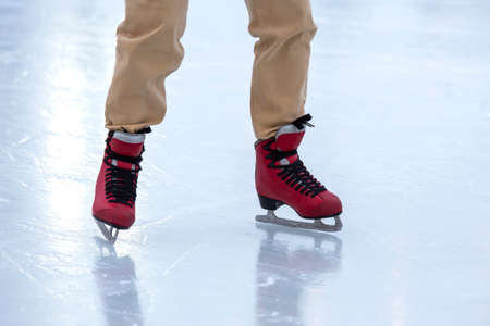 Ice skating on an ice rink. legs with skates. Winter active sport and leisure hobby.