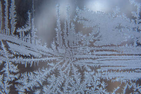 frosty patterns on the window glass closeup. natural textures and backgrounds. ice patterns on...