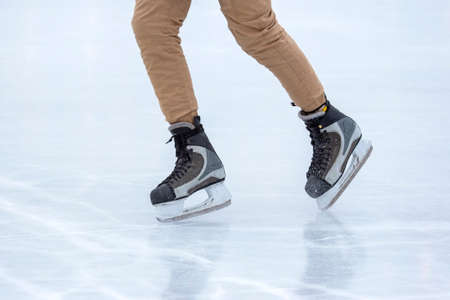 Ice skating on an ice rink. legs with skates. Winter active sport and leisure hobby.の写真素材