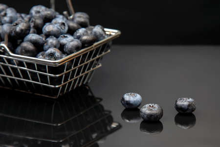 Fresh blueberries in a grocery basket on a background with a mirror image. vitamin food for health