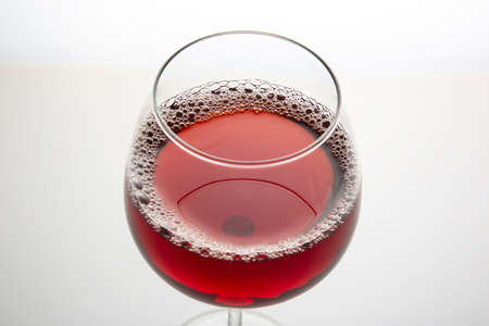 red wine out of a glass on a light background. alcoholism and addiction. drinks for the holidayの写真素材