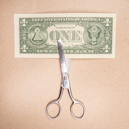 scissors for cutting dollar on paper backgroundの写真素材