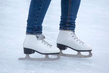 Ice skating on an ice rink. legs with skates. Winter active sport and leisure hobby.