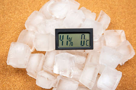 digital thermometer for measuring air temperature and humidity against the background of frozen ice