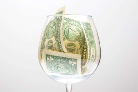dollar banknotes money lies in an empty wine glass. business in the wine industry. alcohol marketing