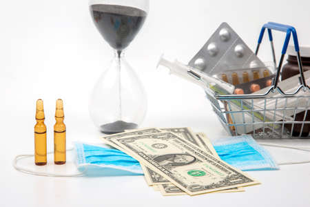 pills, ampoules and syringe for injection, money dollars and hourglass on a white background. business and medicine.の写真素材