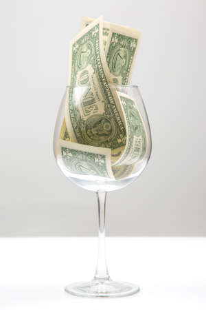 dollar banknotes money lies in an empty wine glass. business in the wine industry. alcohol marketingの写真素材