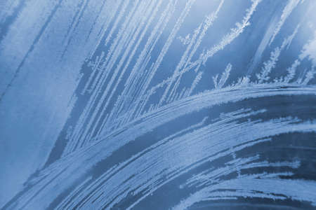 frosty patterns on the window glass closeup. natural textures and backgrounds. ice patterns on...