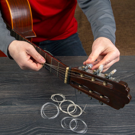 replacement and insertion of nylon strings in a classical guitar. lesson for a musicianの写真素材