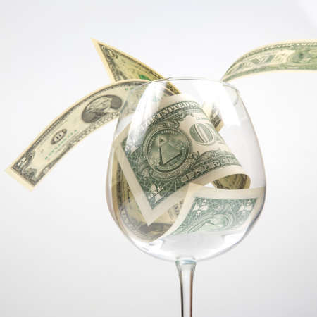 dollar banknotes money lies in an empty wine glass. business in the wine industry. alcohol marketingの写真素材