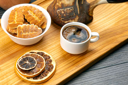 fresh hot coffee with turkey and dried citrus on a kitchen wooden board.