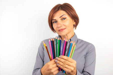 woman demonstrates colored pencils in her hands.