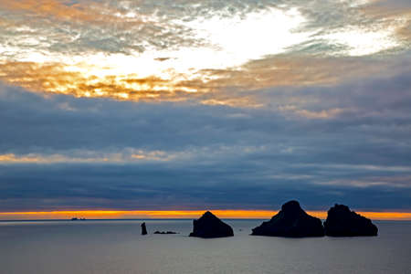 Rocks in the ocean against the evening sky