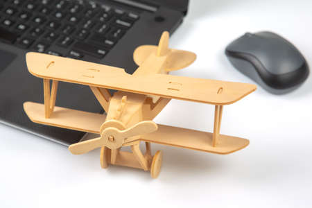 Model of a wooden plane on the background of a laptop. business development and success. Dream to...