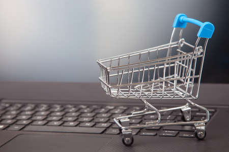 Model of a grocery cart on the background of a laptop. online shopping websitesの写真素材