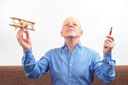 Business man dreams of his achievement. business dream concept. A man holds a wooden airplane model...
